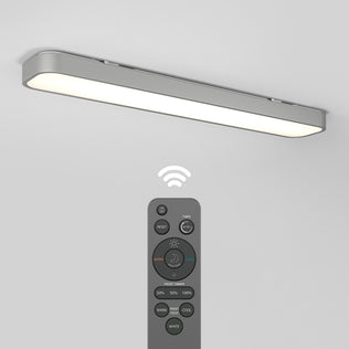 The Artika Europa 36 LED flush mount light is installed on a white ceiling, with its remote control—featuring multiple buttons and a wireless signal icon—placed below the light.
