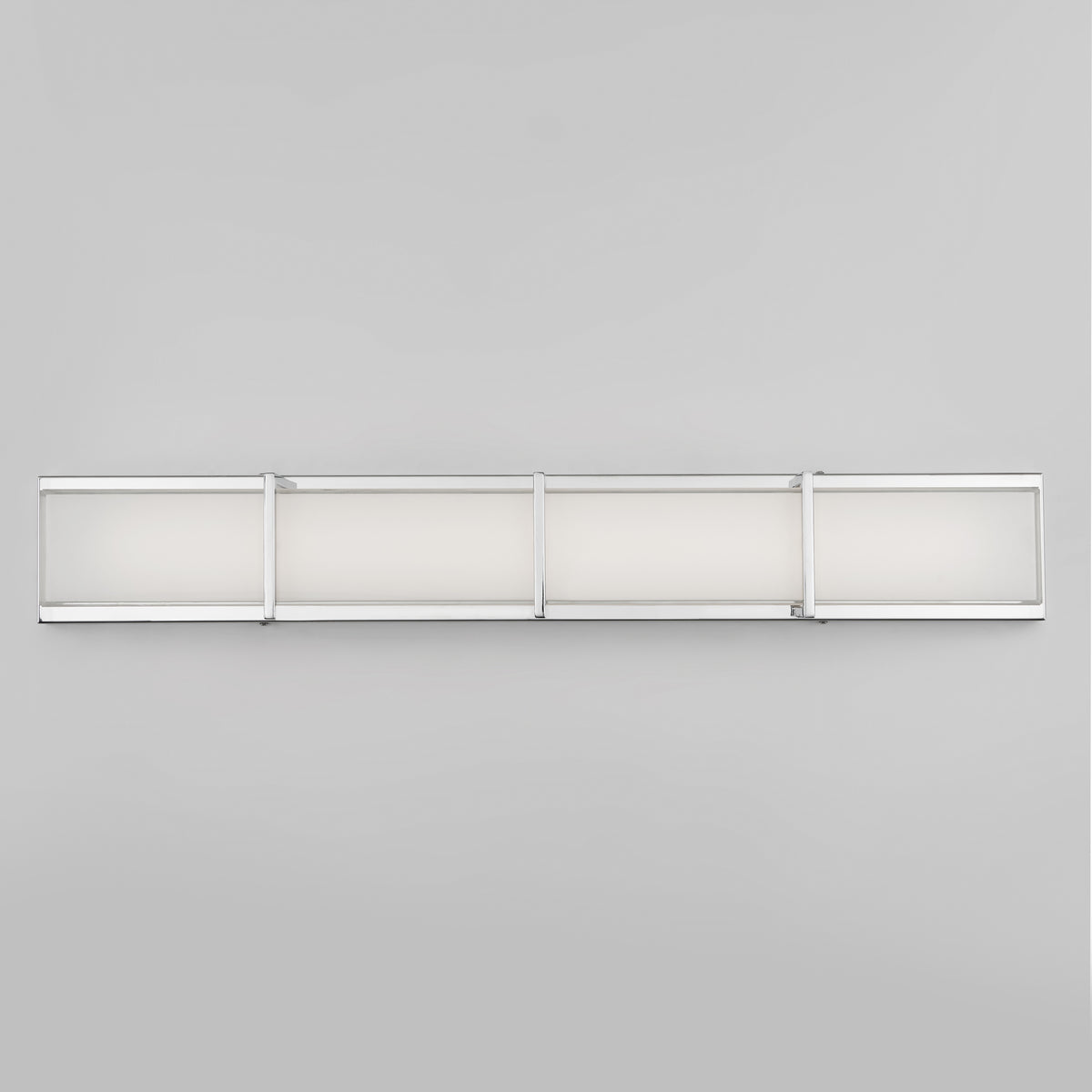 A modern, rectangular wall light fixture with four frosted glass panels framed in silver metal, mounted horizontally on a plain light gray wall.