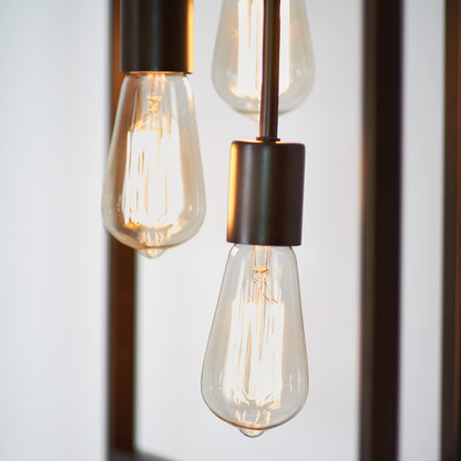 Close-up of the Artika Yale 3-light Chandelier featuring three glowing vintage-style Edison bulbs with visible filaments in dark metal fixtures, set against a softly blurred background.