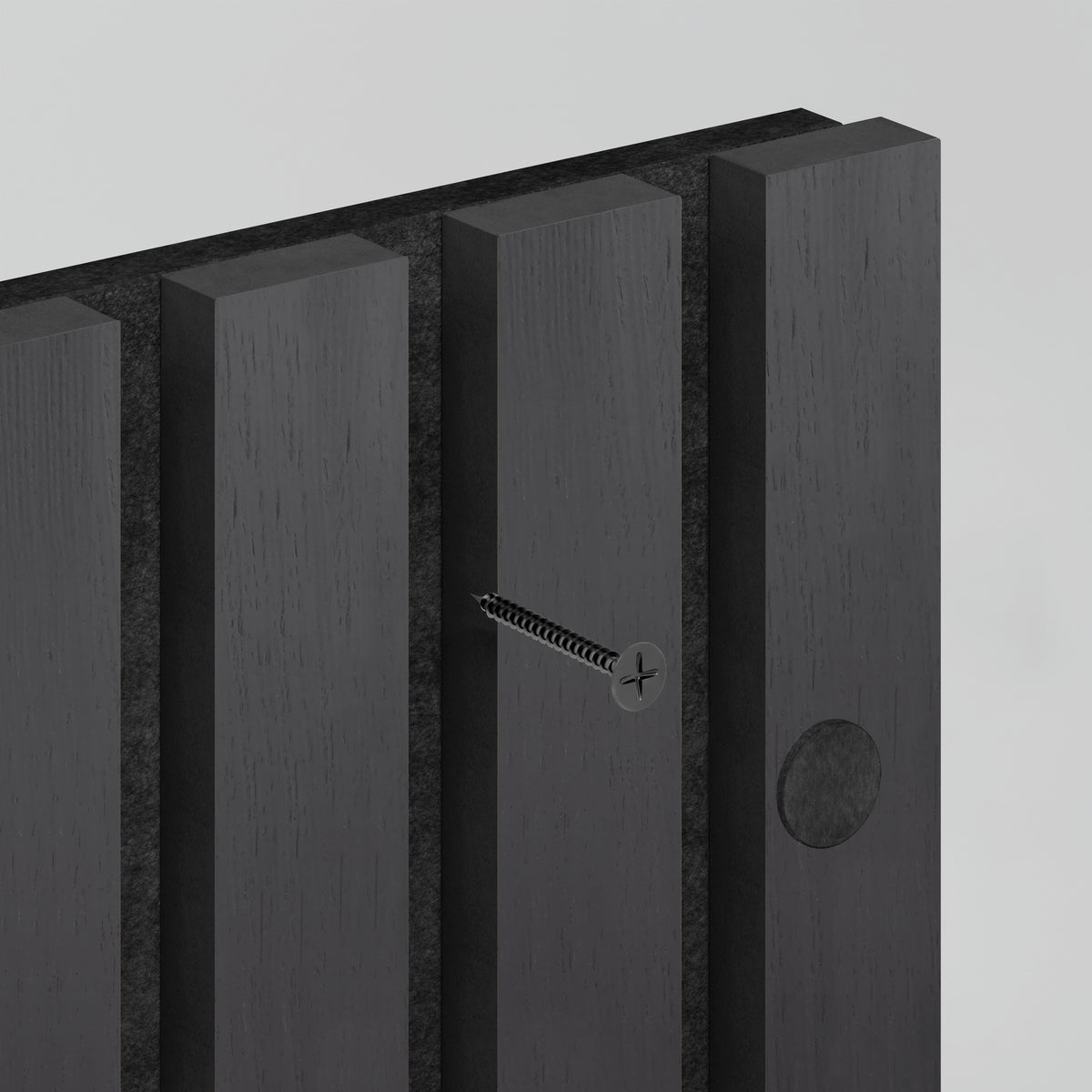 A close-up of a dark wooden panel with vertical grooves, showing a screw partially inserted into one groove and a circular indentation on another panel. The background is plain and light-colored.