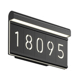 A modern, rectangular black address plaque with the numbers 18095 illuminated in white, mounted on a wall with integrated LED lighting along the top edge.