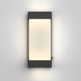A modern rectangular wall light with a black frame and frosted white center, emitting a soft, even glow onto a plain white wall.