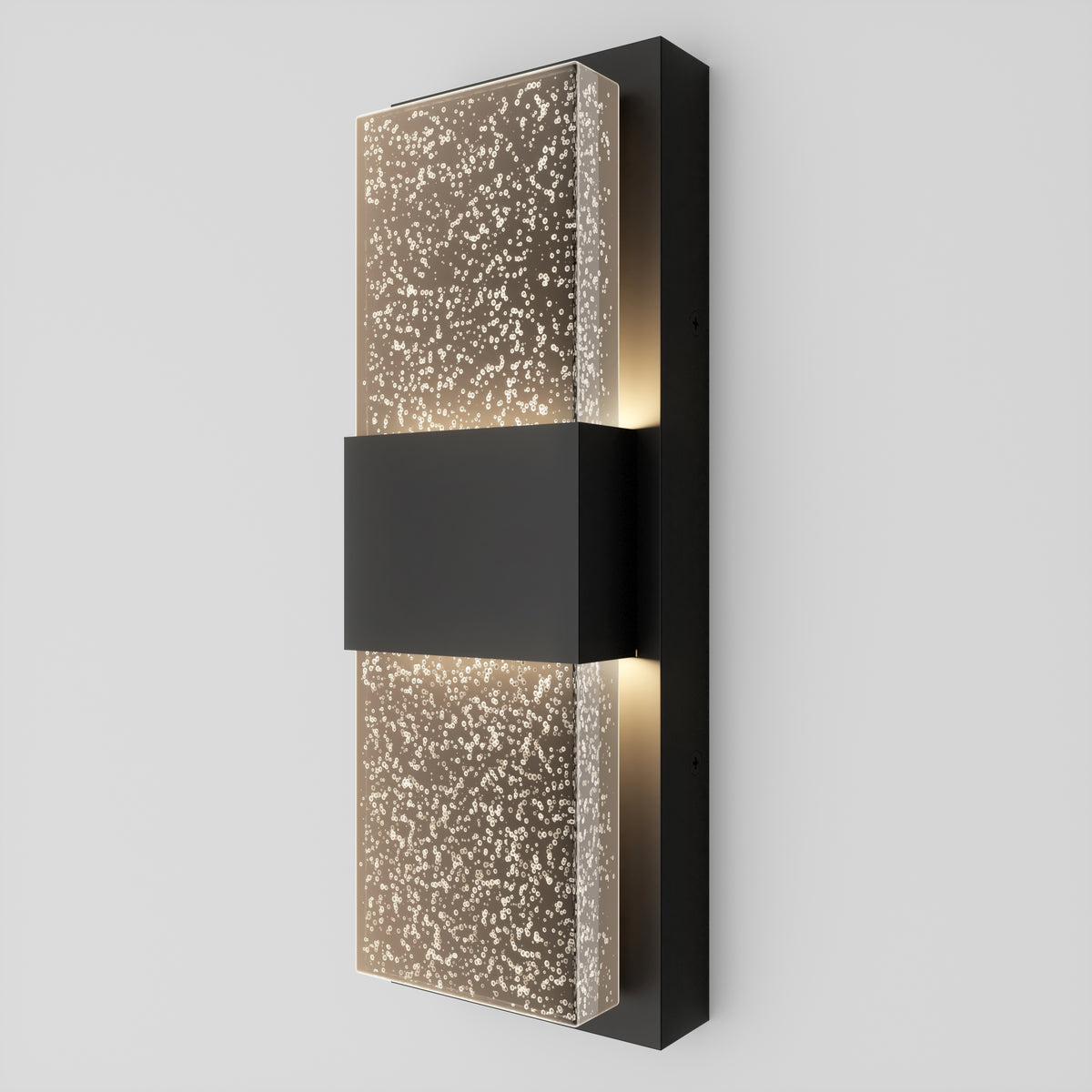 The Artika Mazza Bubble indoor-outdoor LED wall light features a modern design with a rectangular black center and frosted glass panels adorned with a dotted pattern, providing soft illumination on any light-colored wall.