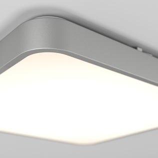 A close-up of the Artika Europa 18 in. LED flush mount light with remote shows its modern, rectangular design with rounded corners, emitting a soft, bright white glow against a light gray ceiling.