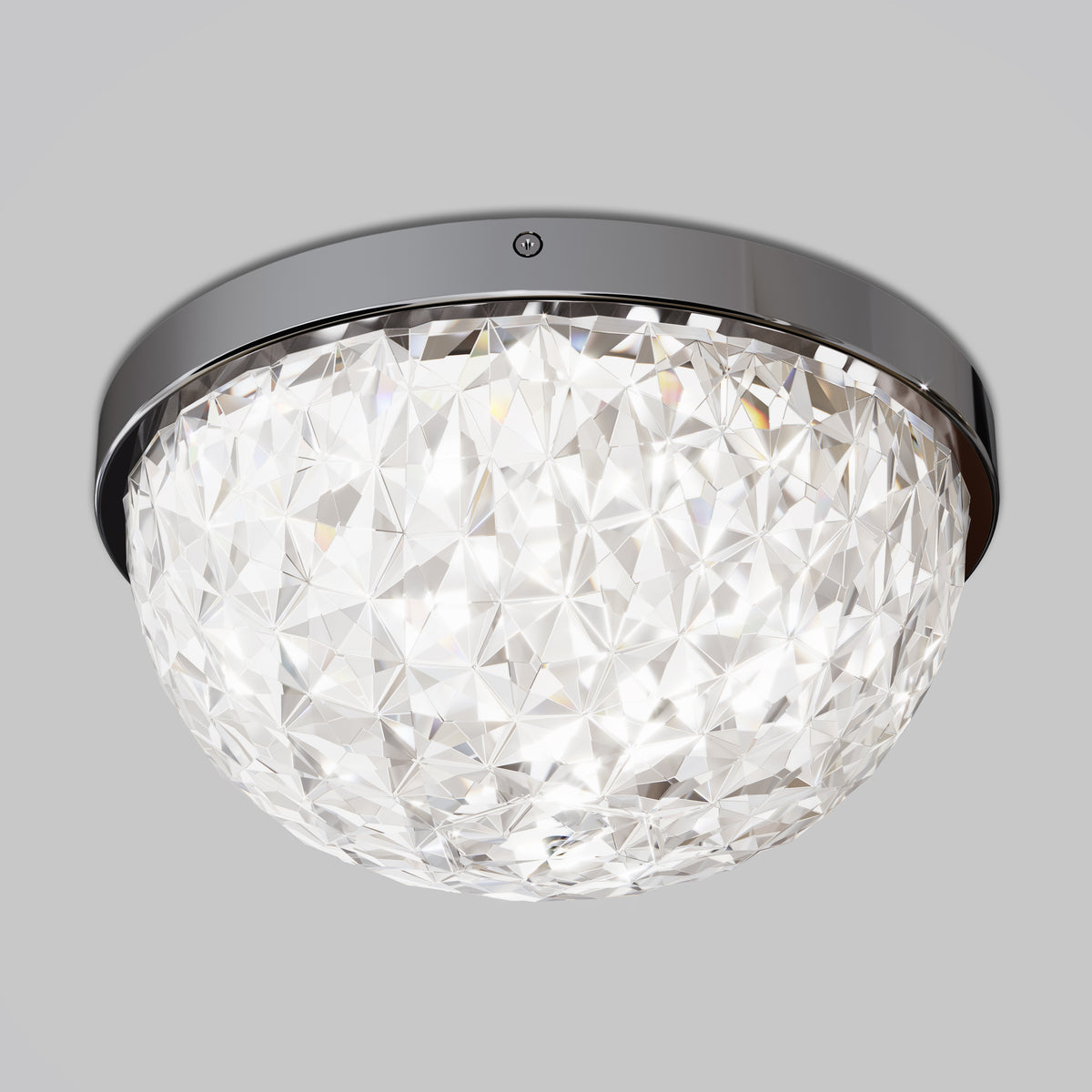 A close-up of a modern crystal ceiling light fixture with a round, faceted glass shade and a glossy metallic rim, mounted against a plain light gray background.