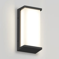 The Artika Faro modern LED indoor-outdoor wall light 3 CCT features a rectangular black frame and frosted white panel, mounted on a light gray wall to emit a soft, diffused glow.