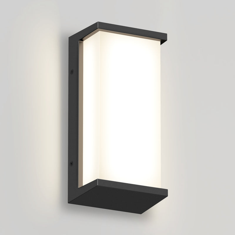The Artika Faro modern LED indoor-outdoor wall light 3 CCT features a rectangular black frame and frosted white panel, mounted on a light gray wall to emit a soft, diffused glow.