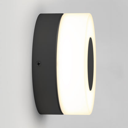 The Artika Ludwig modern LED indoor-outdoor wall light 5CCT features a black base and a circular frosted white cover, mounted on a light gray wall.