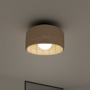 The Artika Emiko modern LED flush mount light 5 CCT features a woven, basket-like shade that emits a warm glow, mounted on a plain white ceiling in a minimalistic modern room.