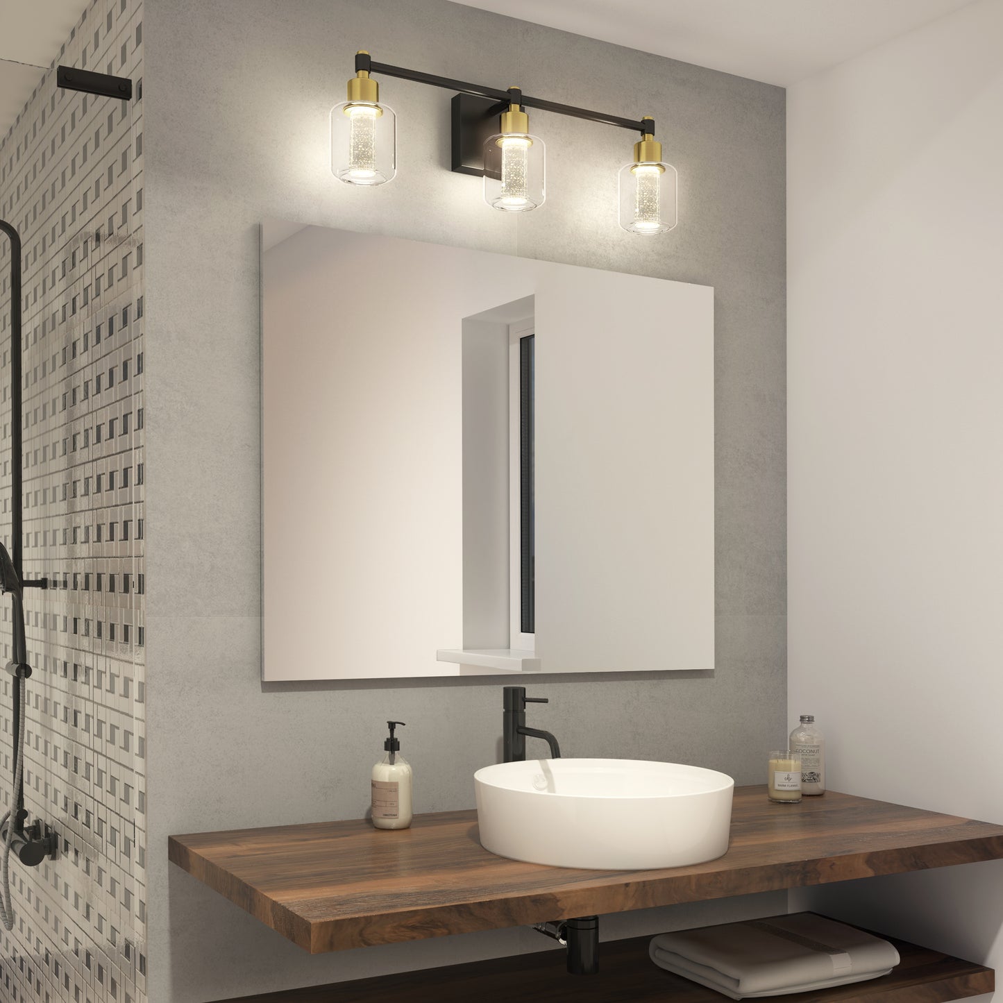 Modern bathroom featuring a round white vessel sink on a wooden countertop, rectangular mirror above, Artika’s Champagne Globe bathroom vanity light with three bulbs, soap dispensers, and a partial view of the shower area.