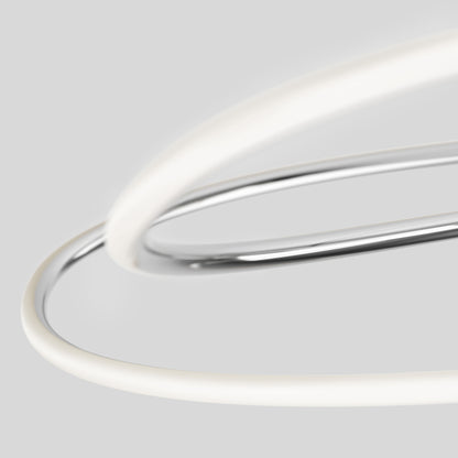 The Artika Swirl Butterfly LED contemporary pendant light features metallic and white tubes that intertwine against a plain light gray background, forming an abstract, minimalist design.