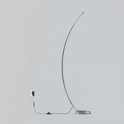The Artika Arc LED Floor Lamp features a minimalist, modern arched design with a slim curve and round base. This dimmable floor lamp includes a visible black cord and switch, plugged into a wall outlet against a light gray background.