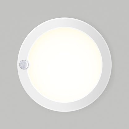 The Artika Accent under cabinet LED light 3CCT is a round, white fixture with a glowing center and a small sensor on the edge, designed for mounting on flat surfaces.