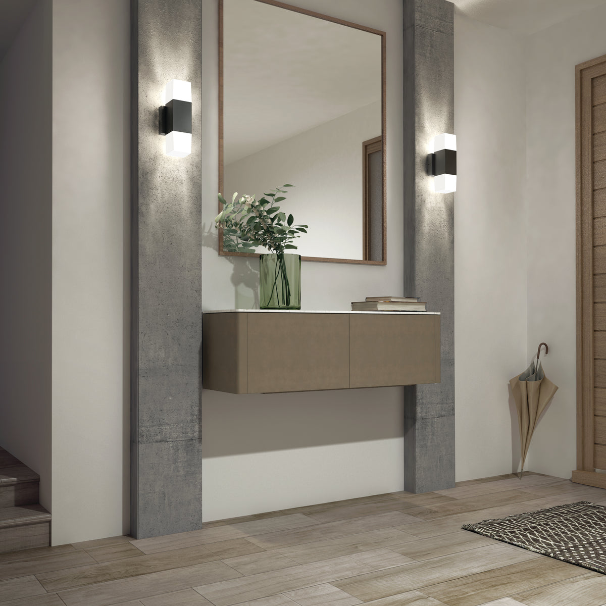 A modern hallway features a floating beige cabinet, large mirror, green vase with leafy branches, umbrella, woven mat on light wood flooring, and two Artika Lennox indoor-outdoor LED wall lights (3 CCT) on the wall.