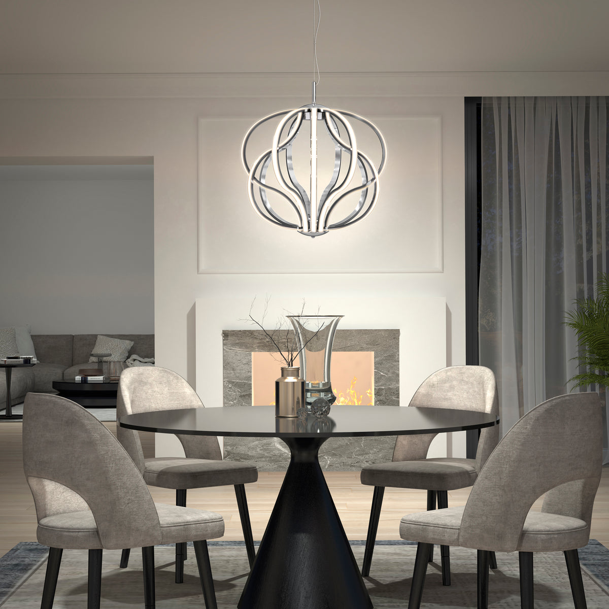 A modern dining room with a round black table, four gray upholstered chairs, a decorative vase centerpiece, and a contemporary spherical chandelier. A fireplace and large windows with curtains are in the background.