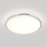 A modern, round ceiling light fixture with a white diffused cover and a metallic rim, emitting a soft, even glow against a plain light gray ceiling.