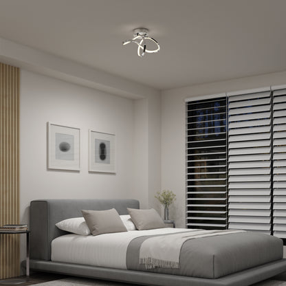 A modern bedroom with a gray upholstered bed, white and gray bedding, abstract wall art, large window with horizontal blinds, an Artika Loop modern LED flush mount light 3 CCT on the ceiling, and a plant on the bedside table.