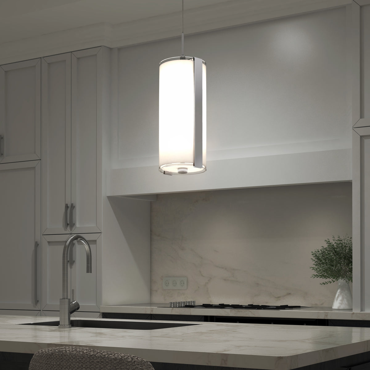 A modern kitchen features a cylindrical pendant light hanging over a marble island with a sink and faucet; gray cabinets, a stove, and a small green plant are visible in the background.