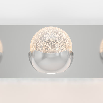 The Artika Oracle LED bathroom vanity light features a clear half-globe with bubbles, a smooth metallic base, and a reflective mount. Its soft glow creates a sleek, contemporary look perfect for modern bathrooms.