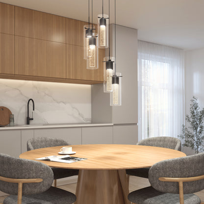 A modern kitchen featuring light wood cabinets, a round wooden table set for one, four gray cushioned chairs, and the Artika Essence 5-light LED pendant. Sunlight filters in through sheer curtains.