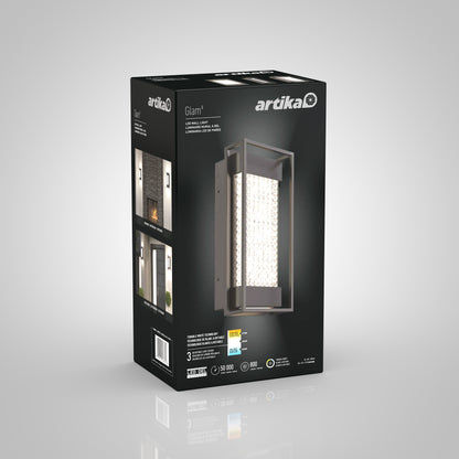 A 3D-rendered box for the Artika Glam indoor-outdoor LED wall light displays an image of the rectangular fixture with a crystal-like insert, product details, and photos of it installed on a modern exterior wall.