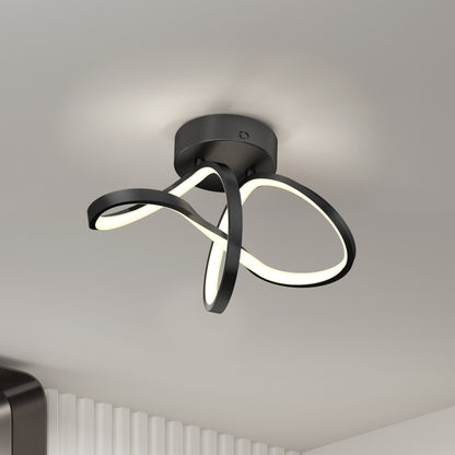 The Artika Loop modern LED flush mount light 3 CCT features intertwined black metal loops with integrated LEDs, mounted on a white ceiling above a room with white vertical wall panels.