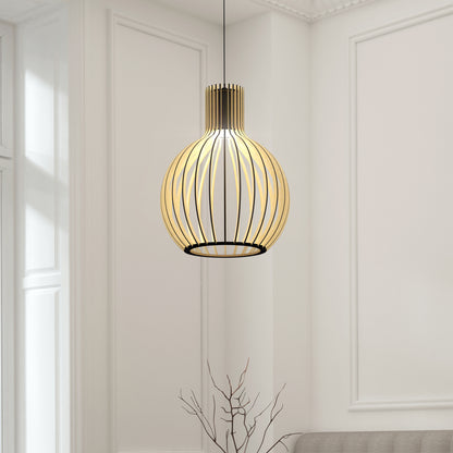 The Artika Tomi LED Pendant Light 3 CCT, featuring a modern spherical black metal frame, hangs in a bright minimalist room with white walls and wainscoting. A bare branch decor is placed below the fixture.