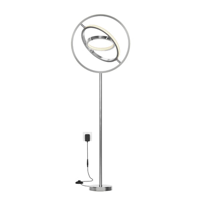 The Artika Pivot modern LED floor lamp 3 CCT features two concentric circular LED rings, a slim silver metal stand, and plugs into a wall outlet.