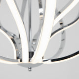 Close-up of a modern chandelier with curved, chrome arms and integrated LED light strips, set against a plain, light gray background.