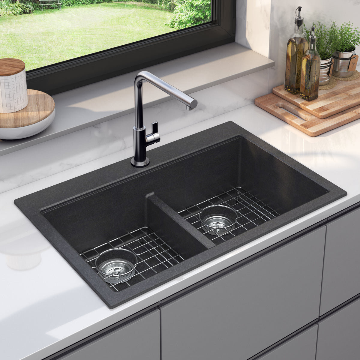 Artika Baycrest 33″ black double-bowl sink with silver faucet in a white countertop near window and cutting board.