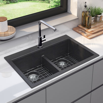 Artika Baycrest 33″ black double-bowl sink with silver faucet in a white countertop near window and cutting board.