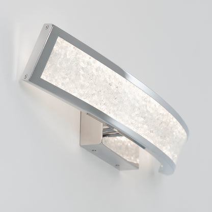 The Artika Glitter LED bathroom vanity light features a curved, rectangular chrome frame and textured frosted glass panel, casting a soft white glow perfect for modern spaces.