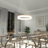 A modern dining room with a glass table, six wooden chairs, a circular pendant light, large window with sheer curtains, minimalist wall art, a sideboard, and potted plants.
