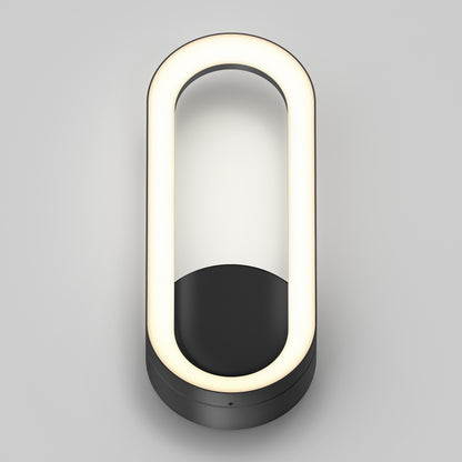 The Artika Aiden modern LED indoor-outdoor wall light 5 CCT features an oval design with a glowing white LED ring and a matte black base, shown mounted on a light gray background.