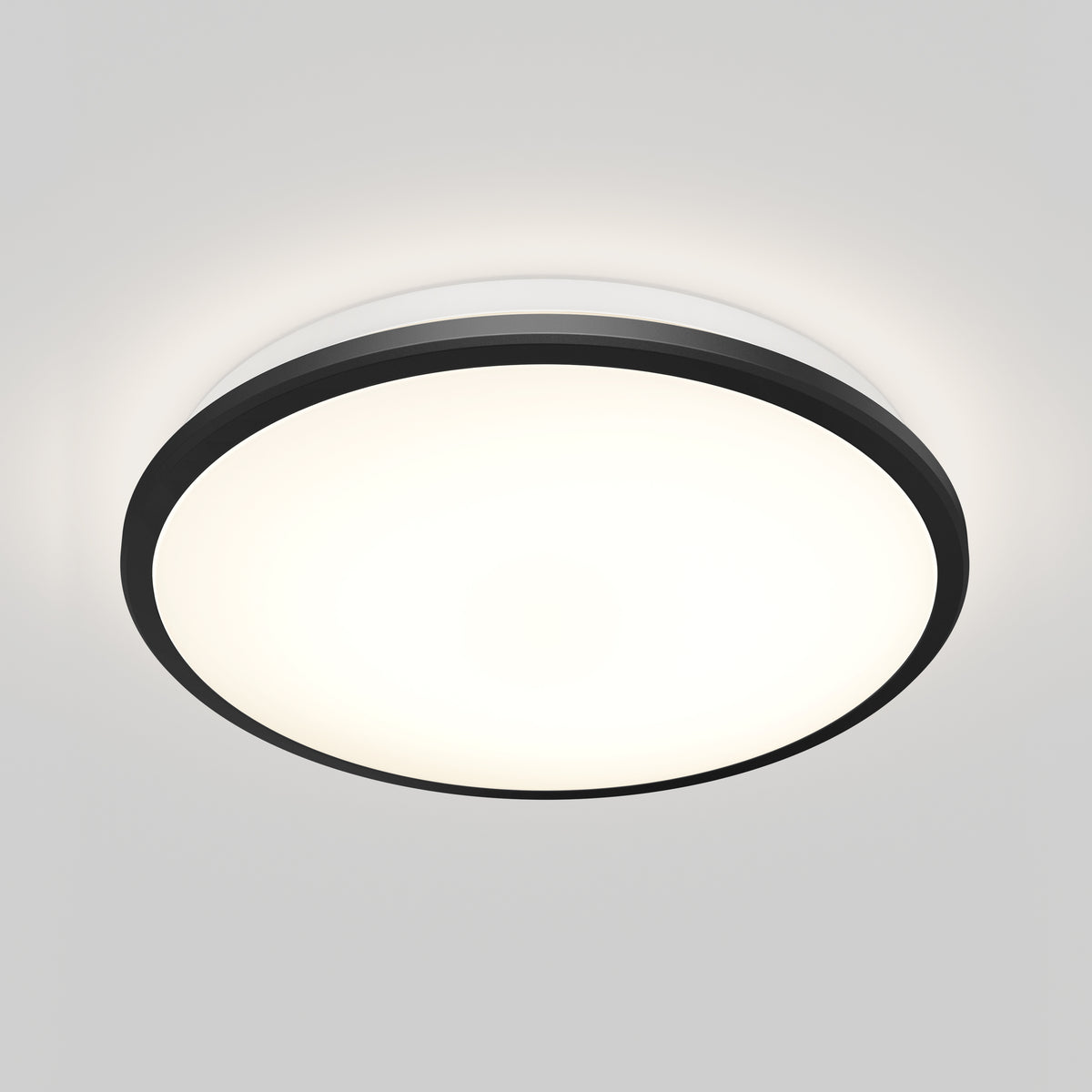 A round, flush-mounted ceiling light with a black rim, glowing brightly against a plain white ceiling.