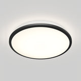 A round, flush-mounted ceiling light with a black rim, glowing brightly against a plain white ceiling.