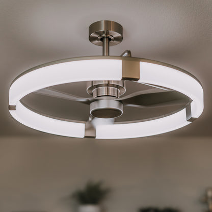 Modern ceiling fan with a circular LED light fixture and three metallic blades, mounted on a white ceiling. The design is sleek and contemporary, with soft lighting and a minimalist look.