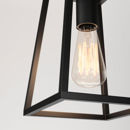 Close-up of the Carter 1-light pendant by Artika, featuring a lit vintage-style filament bulb within a modern geometric black metal frame, set against a plain white background.