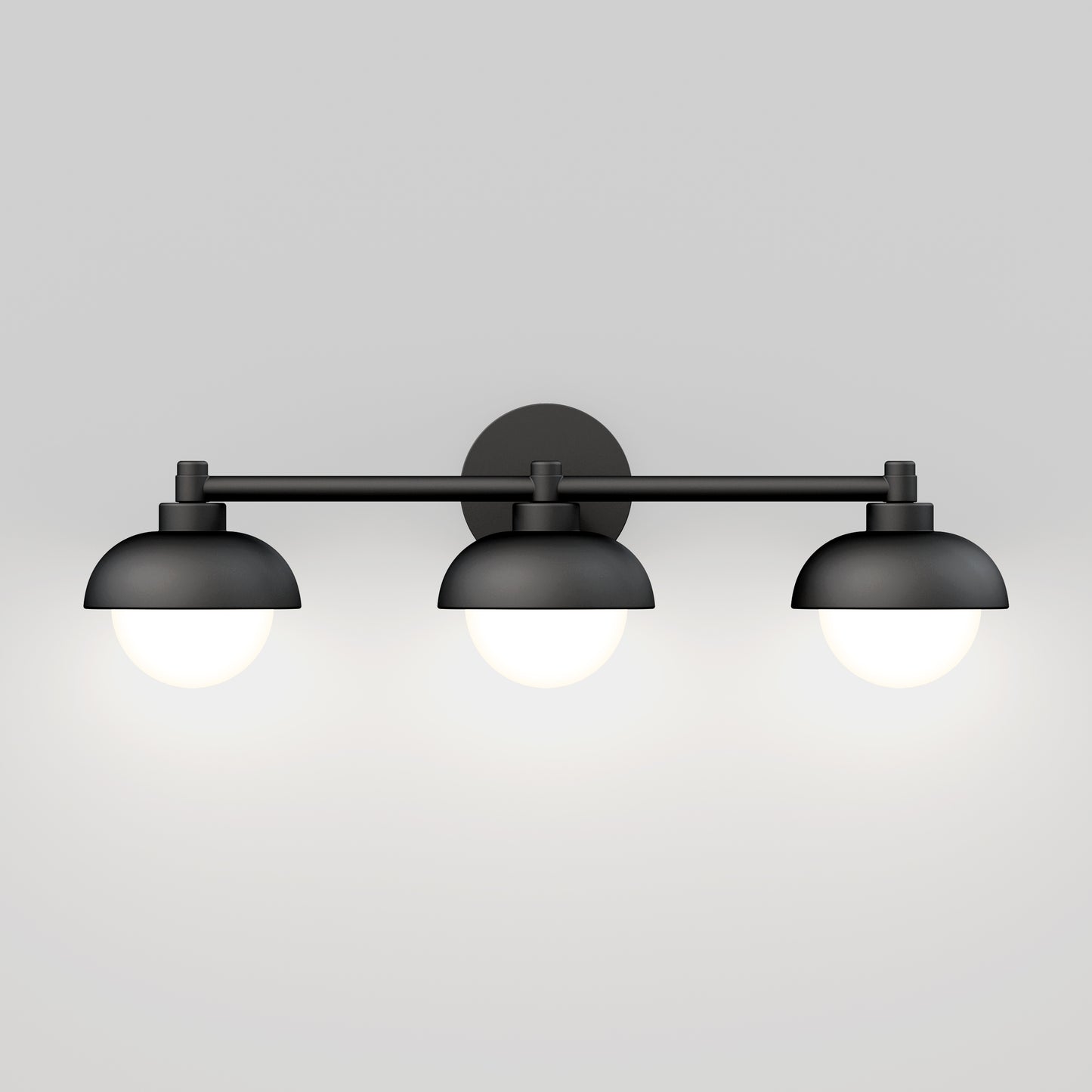 The Artika Boden LED mid-century bathroom vanity light features a black wall-mounted design with three dome-shaped shades, each housing a glowing round bulb, set against a plain light gray background.
