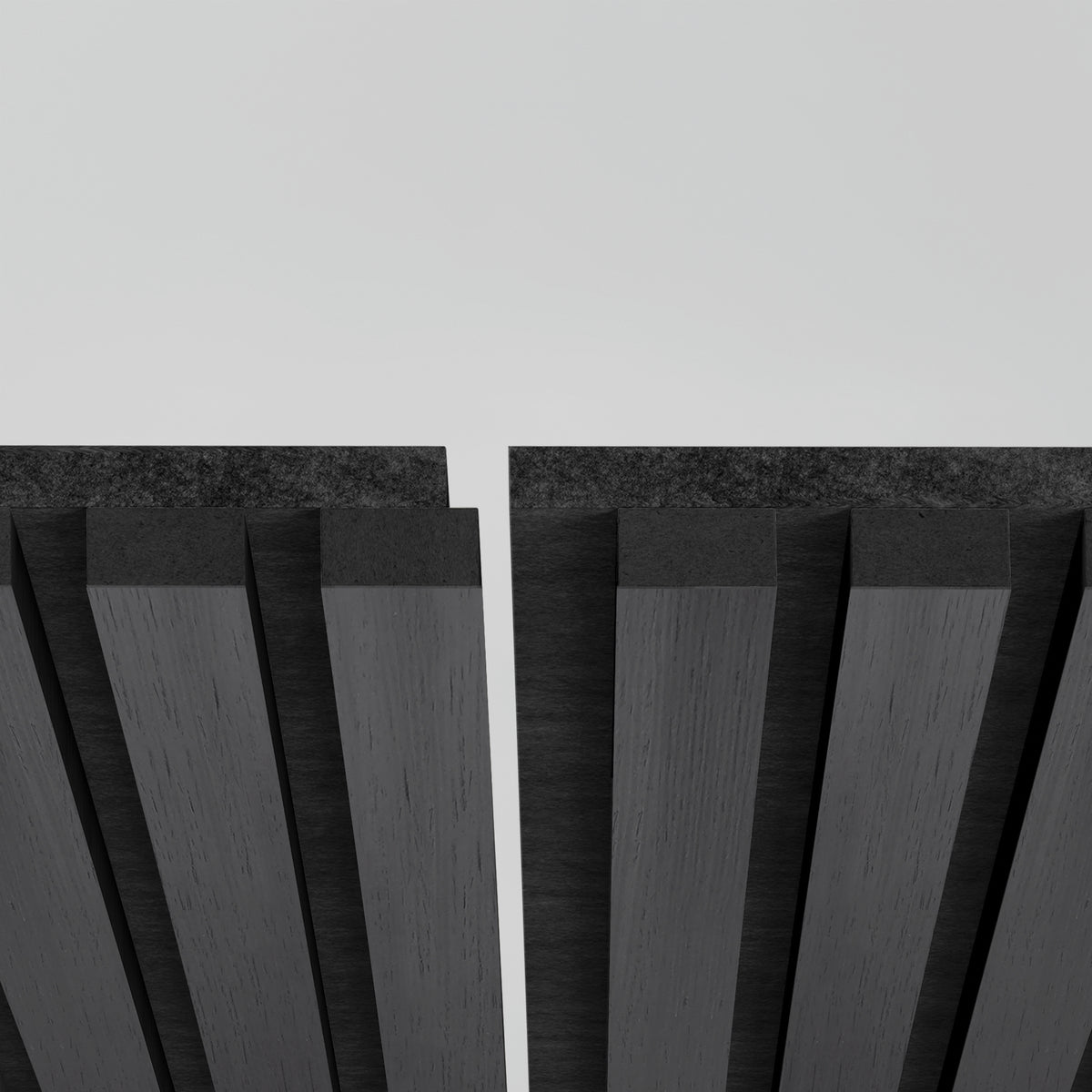 Close-up of two parallel black acoustic panels with vertical grooves, separated by a narrow gap, against a plain light gray background.
