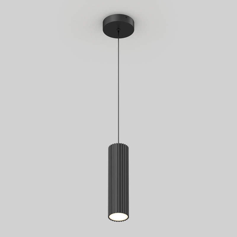 The Artika Groove LED modern pendant light 3 CCT features a black cylindrical, vertically ribbed shade hanging from a slim black cord with a round ceiling mount, set against a plain light gray background.