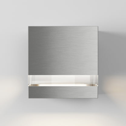 The Artika Valor Square LED indoor-outdoor wall light features a modern brushed metal design with a horizontal frosted glass strip, casting soft white light on a plain light gray wall.