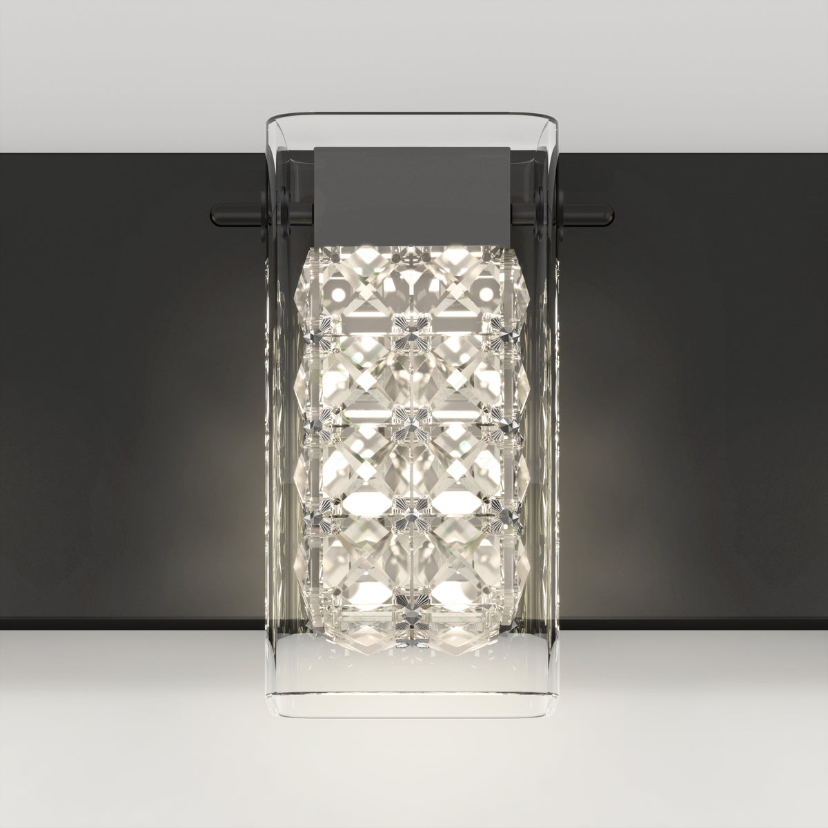 The Artika Crystal Cube LED bathroom vanity light features a clear geometric glass cover, a metallic black base, and bright white LEDs, stylishly mounted on a light gray wall.
