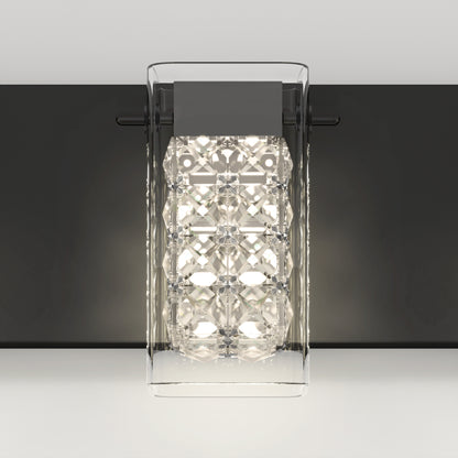 The Artika Crystal Cube LED bathroom vanity light features a clear geometric glass cover, a metallic black base, and bright white LEDs, stylishly mounted on a light gray wall.