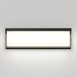 A rectangular, modern wall-mounted light fixture with a black frame and a glowing white center, illuminating the plain light gray wall behind it.
