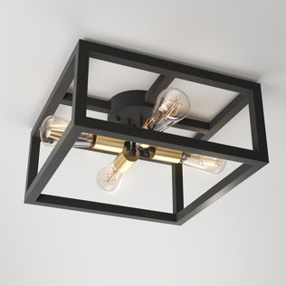 The Artika Princeton 4-light flush mount features a modern black open square frame, brass accents, and four exposed bulbs arranged in a cross pattern.