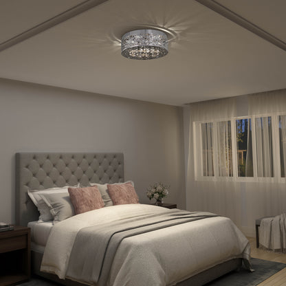 A cozy bedroom with a tufted gray headboard, cream bedding, pink pillows, two bedside tables, flowers in a vase, large window with sheer curtains, and the Artika Crystal Nest LED flush mount ceiling light.