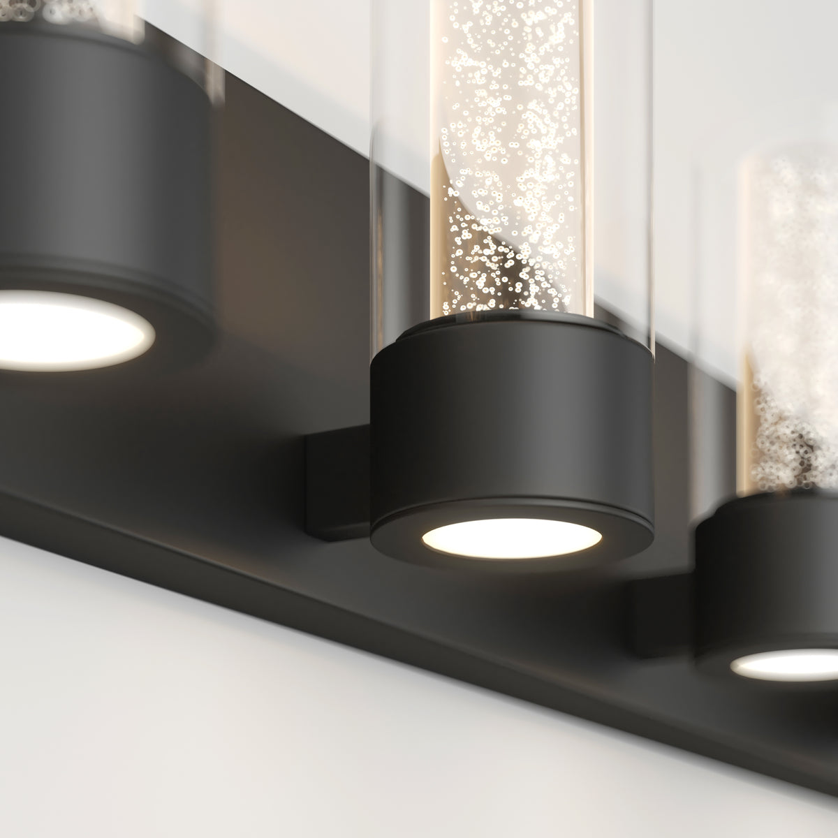 Close-up of Artika Essence 27-in Modern LED Vanity Light, featuring a sleek black base and cylindrical glass shade.