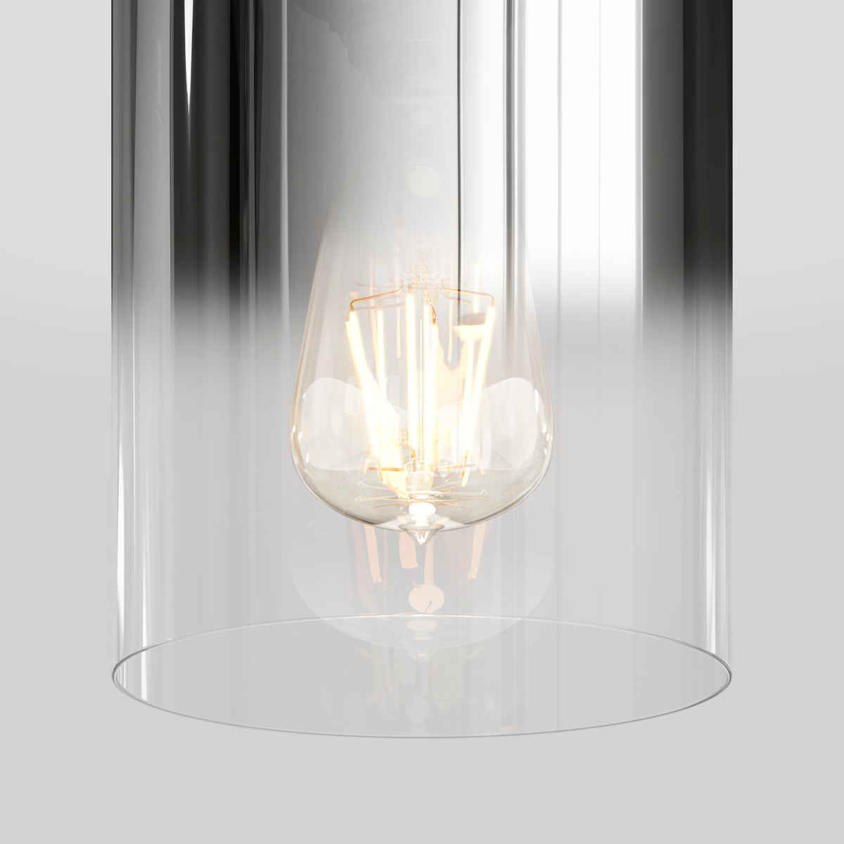 A glowing filament light bulb enclosed in a clear cylindrical glass fixture, set against a neutral gray background.