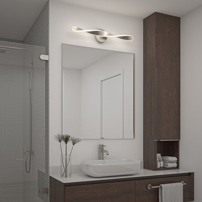Modern bathroom with a rectangular mirror above a sleek sink, Artikas Finley LED modern bathroom vanity light, wooden cabinet, rolled towels, and a glass-enclosed shower with gray tiles.